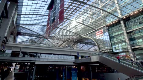 Dentro-De-La-Estación-Principal-De-Trenes-Hauptbahnhof-De-Berlín-Con-Un-Techo-De-Cristal-Futurista-Que-Se-Extiende-Por-Encima-Mientras-El-Tren-Del-Metro-Llega-Al-Nivel-Superior