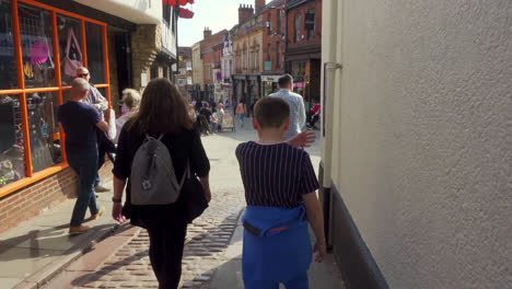 Footage-of-tourists-and-shoppers-walking-around-the-ancient-and-historic-city-of-Lincoln,-Showing-medieval-streets-and-buildings