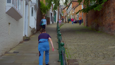 People-walking-around-the-ancient-and-historic-city-of-Lincoln,-Showing-medieval-streets-and-buildings