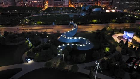 Drohnenaufnahme,-Die-Sich-In-Richtung-Der-Beleuchteten-BP-Brücke-Im-Millennium-Park-Neigt,-Nacht-In-Chicago