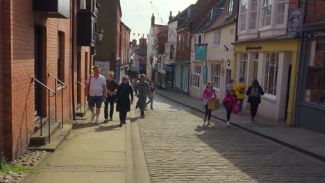 Footage-of-tourists-and-shoppers-walking-around-the-ancient-and-historic-city-of-Lincoln,-Showing-medieval-streets-and-buildings