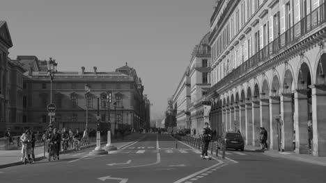 París,-Francia:-Toma-En-Blanco-Y-Negro-De-Automóviles-Moviéndose-Por-La-Calle-Rue-De-Rivoli-Con-Hermosos-Arcos-En-El-Centro-De-París,-Francia-Durante-El-Día