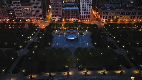 Aerial-view-titling-away-from-the-Cloud-gate,-revealing-skyscrapers-of-Chicago,-summer-dawn-in-USA