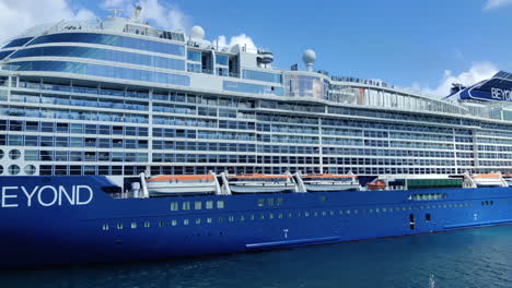 In-a-stunning-display-of-architectural-brilliance,-a-Celebrity-cruise-ship-approaches-the-port,-showcasing-its-captivating-design-from-a-side-view-|-Tourism,-Tourists,-Island,-cruising,-lifestyle