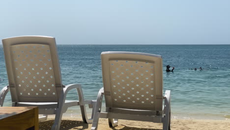 Liegestühle-Am-Strand-Eines-Karibischen-Resorts-Und-Wunderschönes-Blaues-Wasser