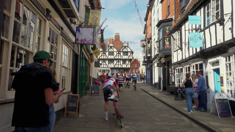 Cyclists-and-people-in-the-famous-and-historic-city-of-Lincoln,-Showing-medieval-streets-and-buildings