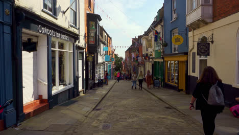 Tourists-and-shoppers-walking-around-the-historic-city-of-Lincoln,-Showing-medieval-streets-and-buildings