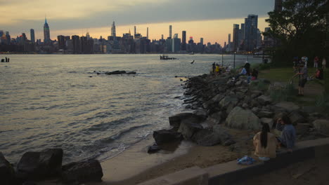 Manhattan,-New-York,-Skyline-Mit-Menschen,-Die-Den-Sonnenuntergang-Von-Der-Brooklyn-Seite-Des-East-River-Aus-Beobachten