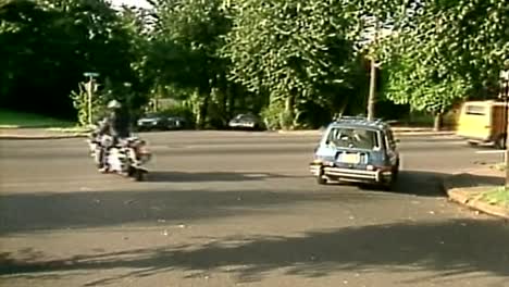 1980S-POLICE-MOTORCYCLE-BIKER-COP-RIDING-INTO-TRAFFIC