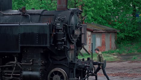 Shot-of-a-maintenance-worker-working-on-a-historic-steam-legion-train-standing-in-Czech-Republic-at-daytime