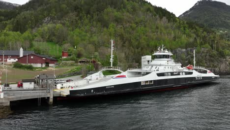 Electric-ferry-Eidsfjord-alongside-Lote-ferry-pier-for-loading-cars-and-charging-batteries---Electric-ferry-from-Fjord-1-company---Aerial-view