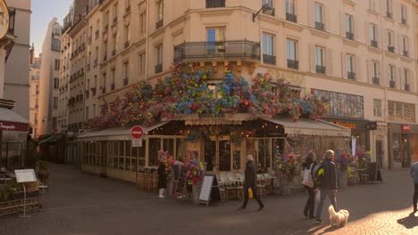 Shot-of-a-typical-restaurant-entrance-decorated-with-colorful-flowers-in-the-center-of-the-capital-in-Paris,-France-on-a-sunny-day
