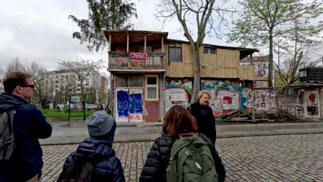 Tour-Guide-Explaining-History-Behind-The-Famous-Treehouse-On-The-Wall-In-Berlin