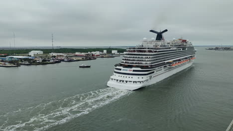 Witness-the-grandeur-of-the-vessel-against-the-backdrop-of-shimmering-waters,-creating-a-sense-of-adventure,-luxury,-and-endless-possibilities-|-Carnival-cruise-ship-gracefully-departing-from-port