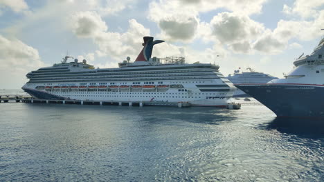 Three-luxury-cruise-ships-of-the-Carnival-Cruise-liner-on-port-in-Cozumel-|-Cinematic-video-of-two-Cruise-ships-of-Carnival-cruise-liner-leaving-from-Port-in-Cozumel-video-in-4K