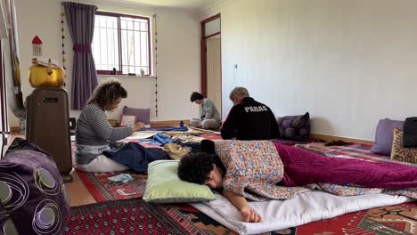 Family-are-working-together-at-home-in-rural-village-area-boy-is-sleeping-mother-is-sewing-and-making-purple-curtain-decoration-concept-and-native-people-home-designing-concept-in-Iran-Arabian-Culture