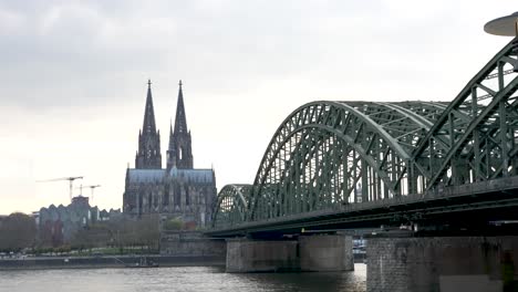 Shot-of-Hohenzollern-Bridge-crossing-river-Rhine-with-Cologne-cathedral-distance-in-Cologne,-Germany-at-daytime