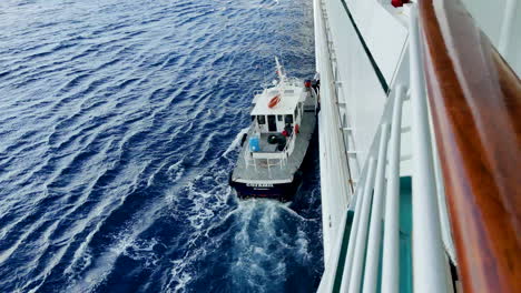 En-Medio-Del-Vasto-Océano,-Se-Desarrolla-Una-Vista-Cautivadora-Mientras-Un-Oficial-Se-Traslada-Del-Crucero-Al-Barco-Piloto.