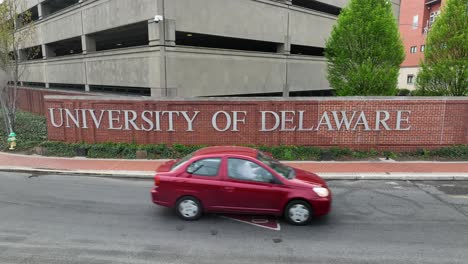 Cars-pass-in-front-of-University-of-Delaware-sign