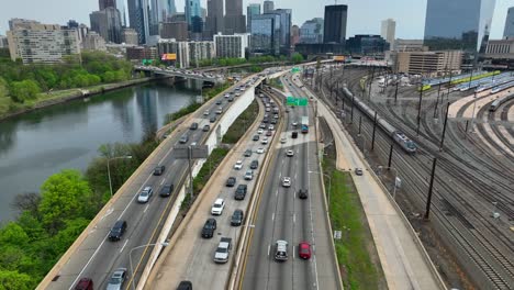 Toma-Aérea-De-Automóviles-Que-Viajan-Sobre-El-Río-Schuylkill-Para-Entrar-Y-Salir-De-Filadelfia.