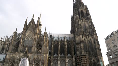 Blick-Hinauf-Zum-Kölner-Dom,-Langsamer-Schwenk-Nach-Links-über-Die-Aufnahme-Zum-Bahnhofseingang