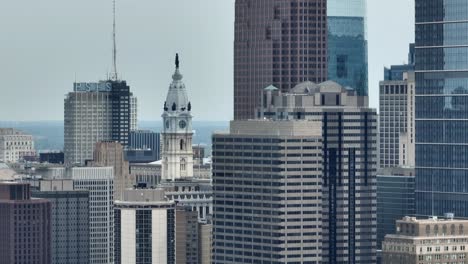 Aerial-rotation-around-city-skyscrapers-and-William-Penn-statue-atop-Philadelphia-City-Hall