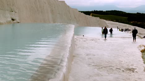 Touristen-Genießen-Den-Besuch-Der-Terrassenförmig-Angelegten-Wasserfälle-Mit-Heißen-Quellen-In-Pamukkale,-Türkei