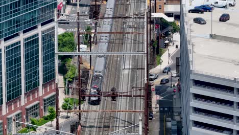 Aerial-view-of-a-train-leaving-the-station-in-New-Brunswick,-New-Jersey