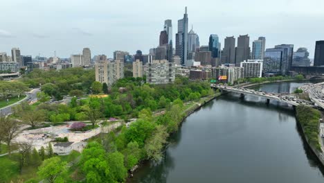 Aerial-drone-flyover-Schuylkill-River-captures-Philadelphia-city-skyline-and-Fairmount-Park