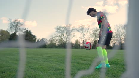 Cinematic-slow-motion-Soccer-player-with-tattoos-practicing-dribbling-right-left-foot-kick-with-colorful-socks-shoes-outfit-spring-green-soccer-field-team-player-team-USA-in-Boston-Massachusetts