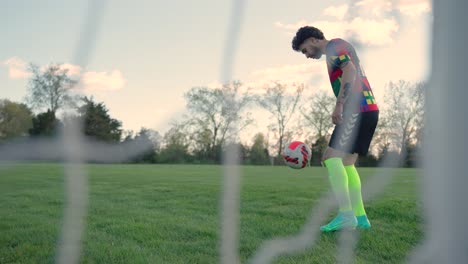 Jugador-De-Fútbol-Cinematográfico-En-Cámara-Lenta-Con-Tatuajes-Practicando-Driblar-Patada-Con-El-Pie-Derecho-Izquierdo-Con-Calcetines-Coloridos,-Traje-De-Zapatos,-Campo-De-Fútbol-Verde-Primaveral,-Equipo-De-Jugadores,-Equipo-De-EE.-UU.-En-Boston,-Massachusetts.