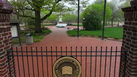 Aufsteigende-Luftaufnahme-Des-Wappens-Der-University-Of-Delaware-Am-Tor-Vor-Dem-Campus-Denkmal