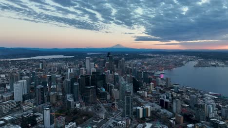 Drone-shot-of-Seattle-at-sunset-with-Mount-Rainier-and-the-Space-Needle-prominently-featured