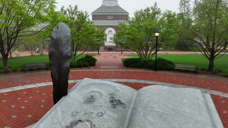 Aerial-flyover-Mentor's-Circle-statue-and-brick-academic-buildings-in-Colonial-Revival-architectural-style