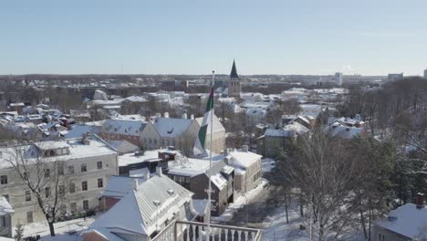Drone-shot-of-Corporation-flag-Liviensis-on-background-we-can-see-Tartu-Old-town-district