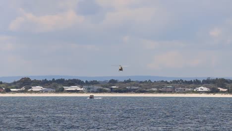 Helicóptero-De-Rescate-Que-Sigue-El-Barco-Guardacostas-Durante-Ejercicios-De-Entrenamiento,-Busselton,-Australia