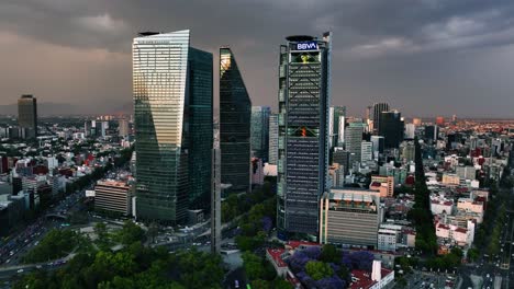 Aerial-view-around-high-rise-at-the-Reforma-avenue,-moody-evening-in-Mexico-city