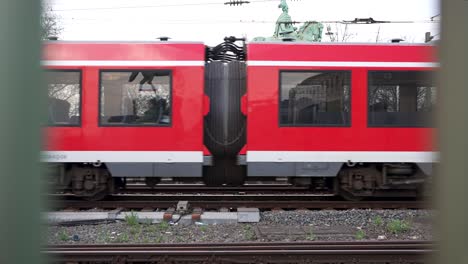 Toma-En-Cámara-Lenta-De-Vagones-De-Pasajeros-De-Un-Tren-En-Colonia,-Alemania-Durante-El-Día