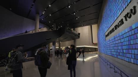 Personas-En-El-Interior-Del-Museo-Y-Monumento-Conmemorativo-Nacional-Del-11-De-Septiembre-Con-Inscripción-En-La-Pared,-Nueva-York