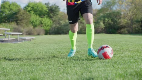 Soccer-player-practicing-dribbling-move-on-lawn-in-sunny-day