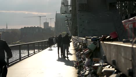 Toma-Cinematográfica-De-Un-Ciclista-Pasando-Por-Candados-De-Amor-En-El-Puente-Hohenzollern-Con-Una-Hermosa-Luz-Solar