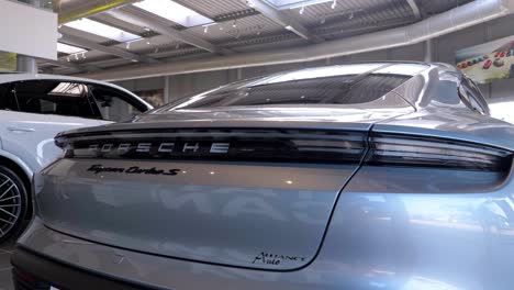 Porsche-Taycan-turbo-S-back-bumper-trunk,-steady-panoramic-pan-shot,-porsche-logo-and-backlights-visible