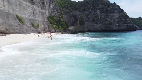 flying-low-over-breaker-waves-and-Tourists-people-relaxing-at-Diamond-Beach-on-Nusa-Penida-Island