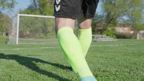 Soccer-player-practicing-kicking-ball-into-goal