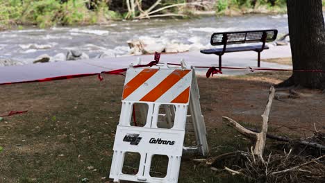 Caltrans-Warnschilder-Vor-Dem-Reißenden-Kern-River-In-Kernville,-Kalifornien,-Die-Den-Fußgängerverkehr-Mit-Herumliegenden-Trümmern-Stoppen