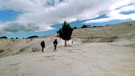 Visitors-to-Pamukkale-walk-barefoot-on-hard-travertine-mineral-formations