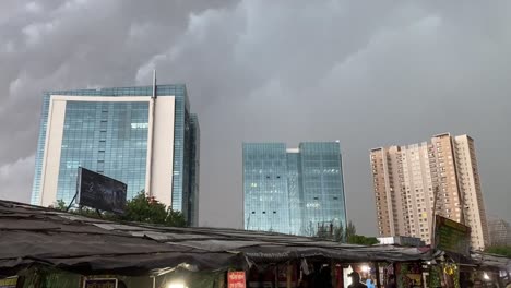 Es-Dreht-Sich-Um-Gebäude-In-Indien-Mit-Schwarzen-Wolken-Im-Hintergrund