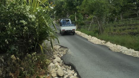 Conduciendo-Una-Camioneta-Con-Jarras-De-Plástico-Vacías-O-Grandes-Botellas-De-Agua-De-Plástico-Vacías-Mientras-Conduce-Por-La-Carretera-De-Nusa-Penia-En-Bali-Indonesia-En-Cámara-Lenta