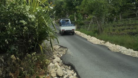 Fahren-Eines-Pick-up-Trucks-Mit-Leeren-Plastikkrügen-Oder-Großen-Leeren-Plastikwasserflaschen-Während-Der-Fahrt-Auf-Der-Straße-Von-Nusa-Penia-Auf-Bali,-Indonesien-In-Zeitlupe