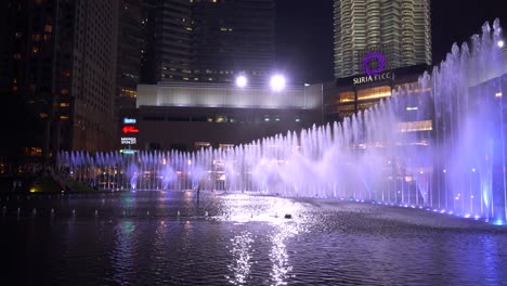 Fast-tilt-and-pan-down-establishing-shot-over-famous-Petronas-Twin-Towers-in-Kuala-Lumpur,-Malaysia